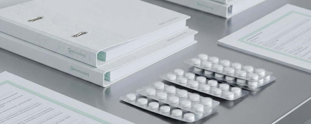 Regulatorische Dokumentation und Medikamenten-Blisterpackungen auf einem klinisch weißen Schreibtisch — Symbol für FDA-Zulassung